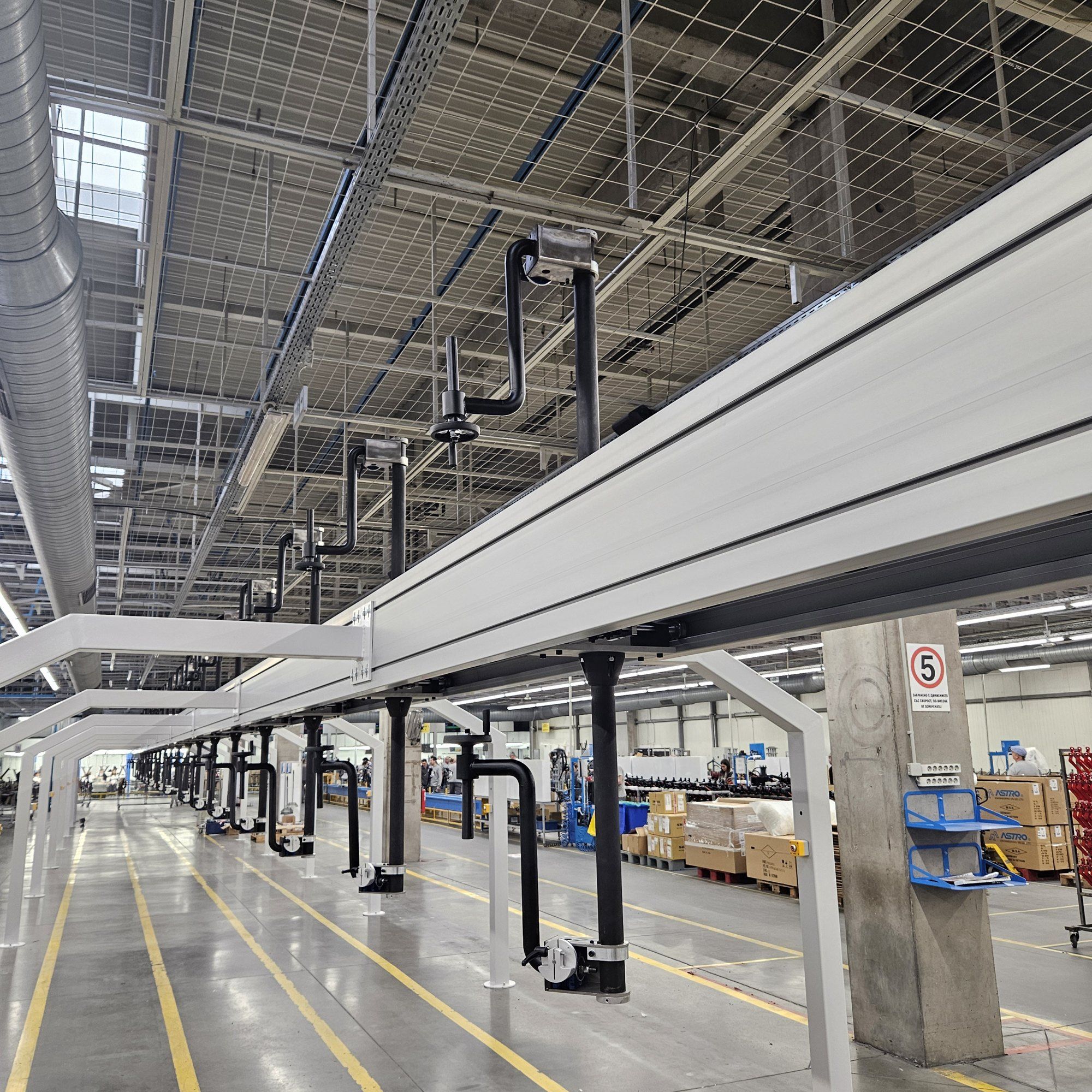 The overhead rail with a row of hangers above the yellow floor lines